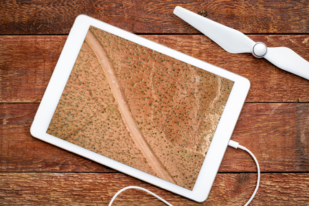 desert road in Moab area, Utah - reviewing an aerial image on a digital tablet