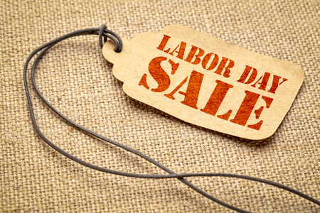 Labor Day sale sign - a paper price tag with a twine against burlap canvasの写真素材