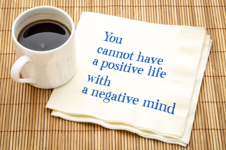 You cannot have a positive life with a negative mind - inspiraitonal text on a napkin with a cup of coffeeの写真素材