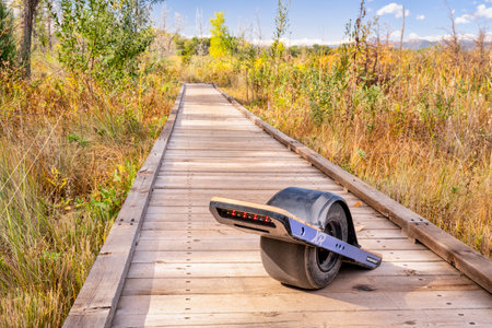 Fort Collins CO, USA -September 24, 2018:  Onewheel electric skateboard on a boardwalk across a...