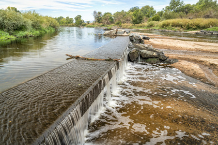 water diversion dam on the South Platte River in northern Colorado below Denver, early fall scenery with low waterの写真素材