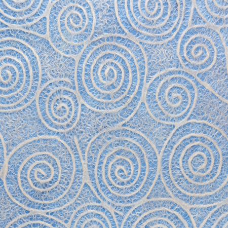 white Japanese Washi tissue with tuquoise Uzumaki pattern spirals against blue mulberry paperの写真素材