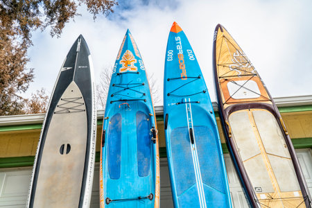 Fort Collins, CO, USA - January 23, 2019: Four different stand up padleboards including touring, racing and expedition by SIC Maui and Starboard on a driveway against garage door.のeditorial素材