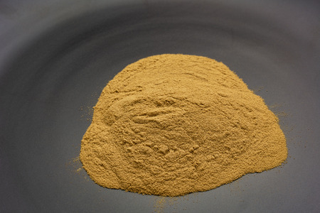 green coffee beans powder - a pile on a ceramic black plateの写真素材