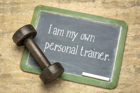 I am my own personal trainer, fintess concept - white chalk text on a slate balckboard with a dumbbellの写真素材
