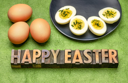 happy easter - text  in vintage letterpress wood type with brown eggs against green textured paper