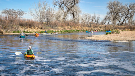 Brighton, CO, USA - April 6, 2019 : A group of paddlers paddling kayaks and canoes after a portage during annual spring trip on the South Platte River below Denver.のeditorial素材