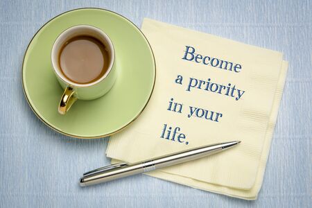 Become a priority in your life - inspirational handwriting on napkin with a cup of coffeeの写真素材