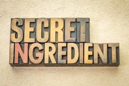 secret ingredient word abstract in vintage letterpress wood type against textured handmade paperの写真素材