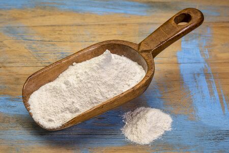 Cassava (yuca) flour on a rustic wooden scoop. It is a gluten free and grain free replacement for wheat flour.の写真素材