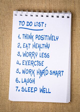 inspiring and positive to do list  - handwriting in a spiral sketchbook against burlap canvas backgroundの写真素材
