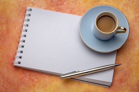 blank spiral art sketchbook with a cup of coffee against textured paper