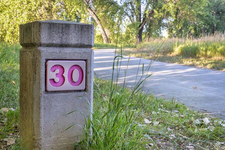 distance marker on Boyd Lake bike trail in northern Colorado, summer morning scenery