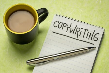 copywriting word - handwriting in a spiral notebooks with a cup of coffee