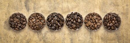 sampler of coffee beans from different parts of the world - overhead view of  round bowls against...