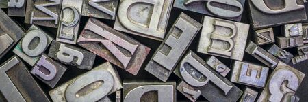 background of random vintage grunge letterpress metal type printing blocks, panoramic banner