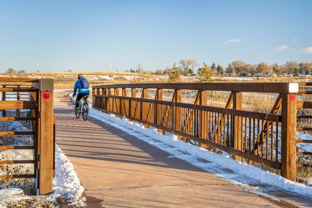 winter commuting by bike on one of numerous biking trails in Fort Collins, northern Colorado, recreation and commuting conceptの写真素材