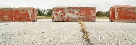 Heavy concrete roadblocks blocking highway or street. Obstacle, dead end  or obstruction to progress concept. Panoramic banner.の写真素材