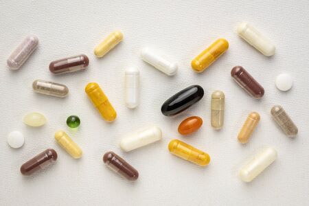 vitamins and supplements background - pills, capsules and tablets on a white art canvas, healthcare, self care and wellbeing conceptの写真素材