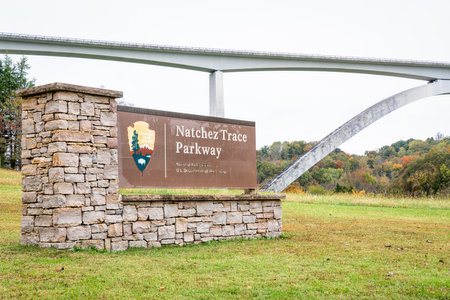Franklin, TN, USA - October, 28, 2019:  Entry sign to  Natchez Trace Parkway, 444-mile recreational road and scenic drive through three states - fall scenery with Double Arch Bridge in background, travel concept.のeditorial素材