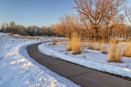 windy bike trail in winter sunset scenery - Poudre River Trail in Fort Collins, Colorado, recreation...