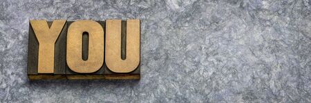 you word in vintage letterpress wood type against gray handmade textured amate paper with copy spaceの写真素材