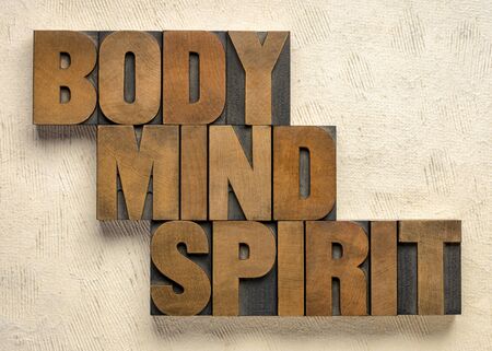 body, mind and spirit - words in vintage wood letterpress printing blocks against textured paper, holistic wellness and lifestyle conceptの写真素材