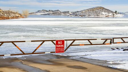 Boat ramp closed for winter on a frozen lake at foothills of Rocky Mountains - Horsetooth Reservoir, a popular recreation destination near Fort Collins in northern Colorado.の写真素材