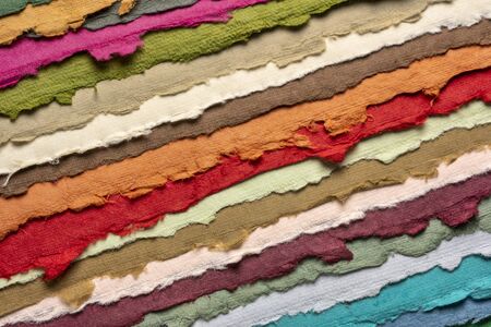 collection of colorful handmade Indian paper sheets with rough edges produced from recycled cotton fabric, art and craft conceptの写真素材