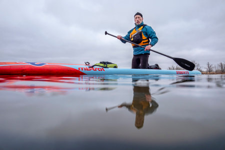Fort Collins, CO, USA - March 14, 2020: A senior male paddler on a long racing stand up paddleboard...