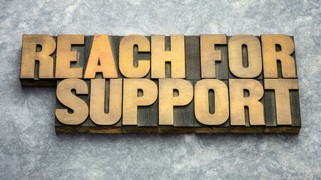 reach for support word abstract in vintage letterpress wood type, web banner for coronavirus pandemic hard timeの写真素材