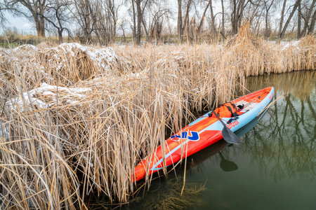 Fort Collins, CO, USA - March 13, 2020: A long racing flatwater stand up paddleboard (Mistral Stealth) on a calm lake after paddling workout in early spring - recreation, training and fitness concept.のeditorial素材