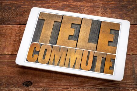telecommute word abstract in vintage letterpress wood type on a digital tablet,  telecommuting,...