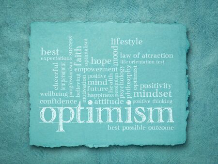 optimism word cloud - handwriting on a blue handmade rag paper, lifestyle, hope and positivity conceptの写真素材