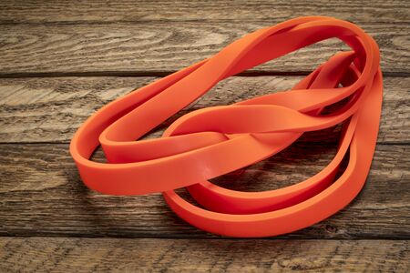 resistance exercise band for fitness and rehabilitation against wooden backgroundの写真素材