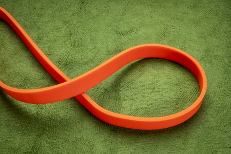 resistance exercise band for fitness and rehabilitation against green backgroundの写真素材