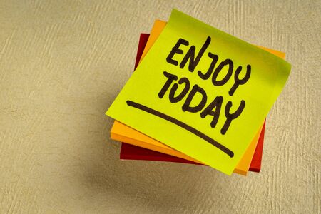 Enjoy today reminder - handwriting on a sticky note, positive attitude and mindset conceptの写真素材