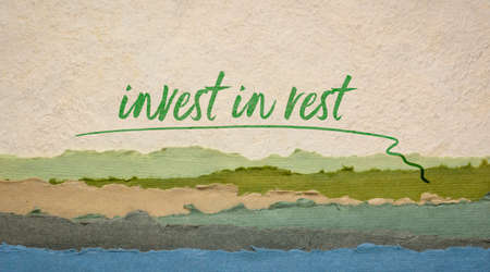 Invest in rest reminder or advice - handwriting on a handmade paper with abstract landscape, healthy...