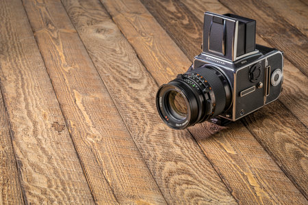 Fort Collins, CO, USA - July 29, 2020: Medium format, classic film camera, Hasselblad 500 cw with 150 mm Carl Zeiss Sonnar lens on wooden background.のeditorial素材