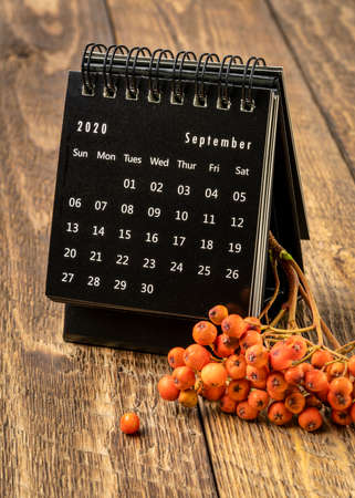 September 2020 - spiral desktop calendar on rustic wood with rowanberry