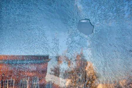 shattered glass window with sky and buildings reflectionsの写真素材