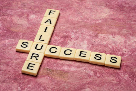 success and failure crossword in ivory letter tiles against textured paper, business, career and personal development conceptの写真素材