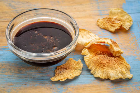 a small bowl of yacon syrup with dried slices of yacon tuber,  a powerful prebiotic sweetener...
