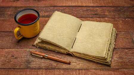 antique leatherbound journal with decked edge handmade paper pages and a stylish pen on a rustic...