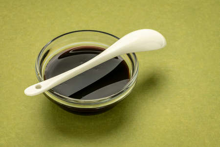 a small bowl of yacon syrup against green handmade paper,  a powerful prebiotic sweetener derived from the yacon rootの写真素材