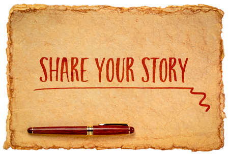 share your story - inspirational handwriting on a tan toned heavyweight deckle edge paper with a stylish pen isolated on whiteの写真素材