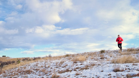 senior man is jogging at foothills of Rocky Mountains - Horsetooth Reservoir area in northern Colorado in winter sceneryの写真素材