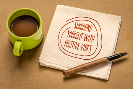 surround yourself with positive vibes - inspirational note on a napkin with a cup of coffee, positivity and personal development conceptの写真素材