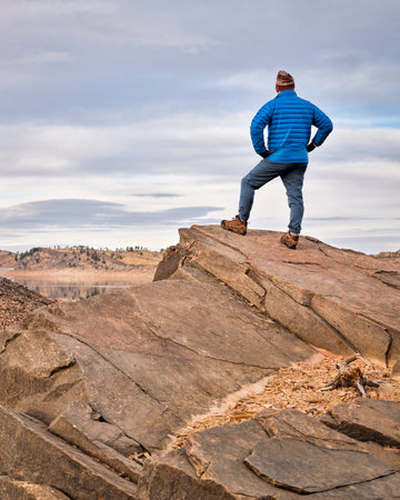 male hiker on a rocky cliff  at foothills of Rocky Mountains, Horsetooth Reservoir area - a popular...