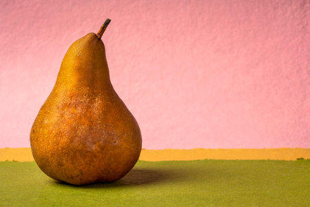 fresh bosc pear against abstract paper landscape, still life with a copy spaceの写真素材